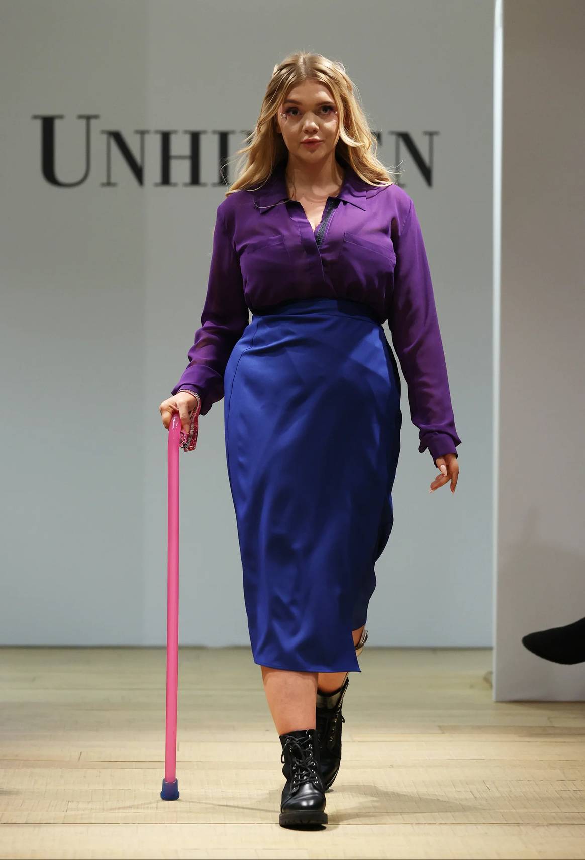 Modelo con bastón en falda cruzada en el show Unhidden el 23 de febrero